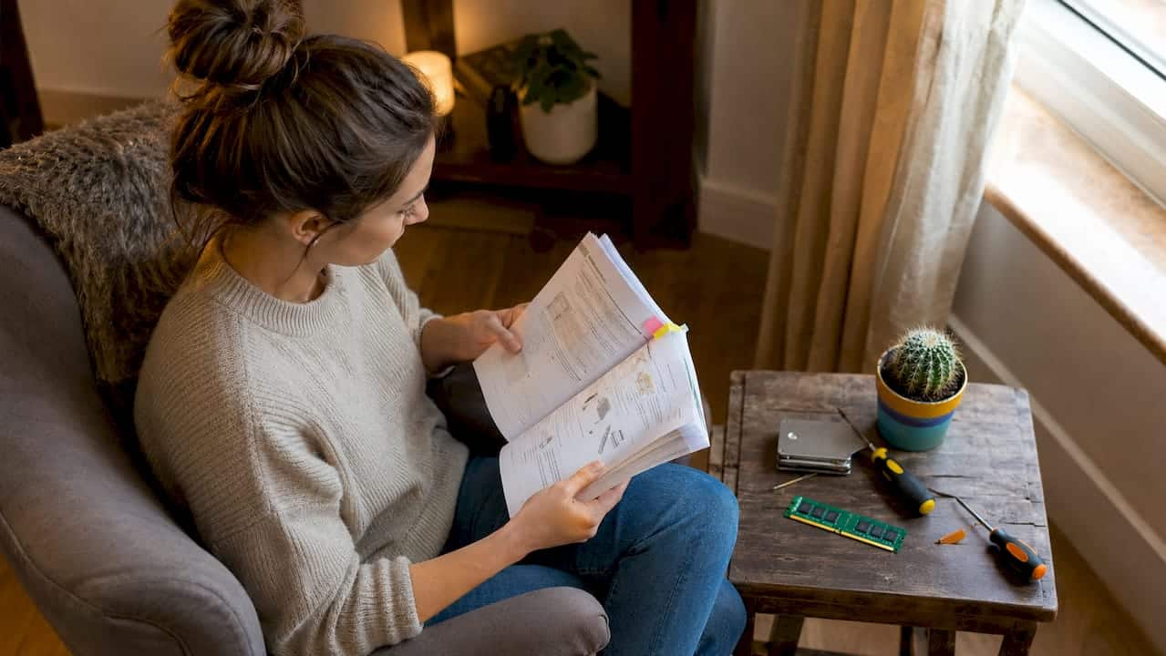 Een vrouw verdiept zich in de handleiding voor zowel hardware als software.